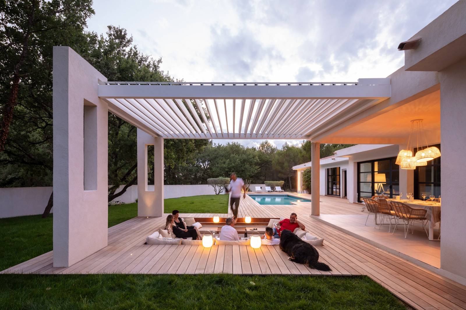 Outdoor patio with sunken firepit and white modern pergola above.