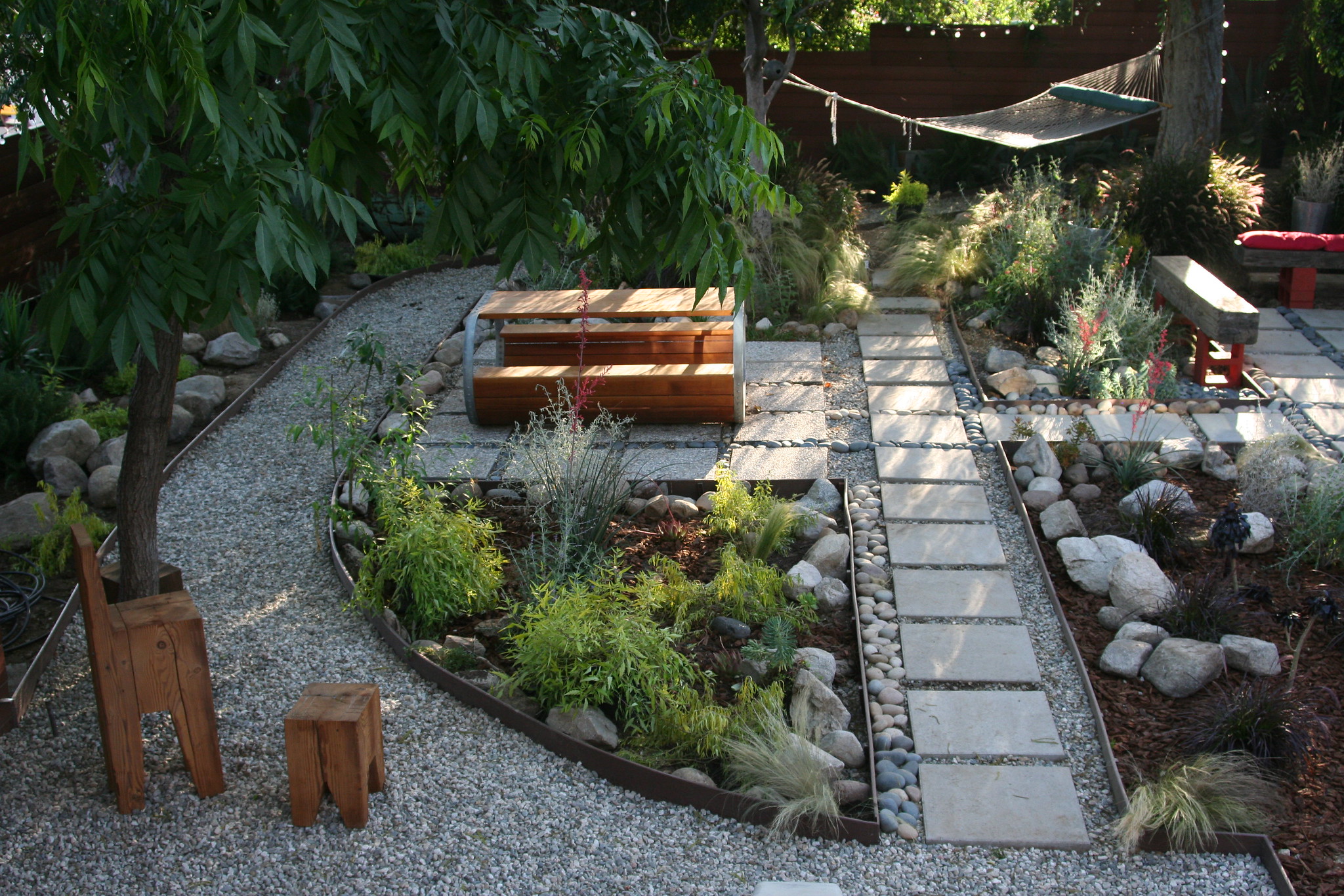 example of a low maintenance landscape with gravel path and stone steppers with native planters
