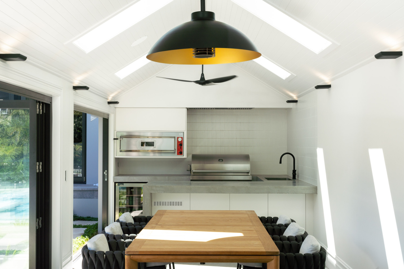 Rolling Stone Landscapes create minimalist interior kitchen under covered pavolion