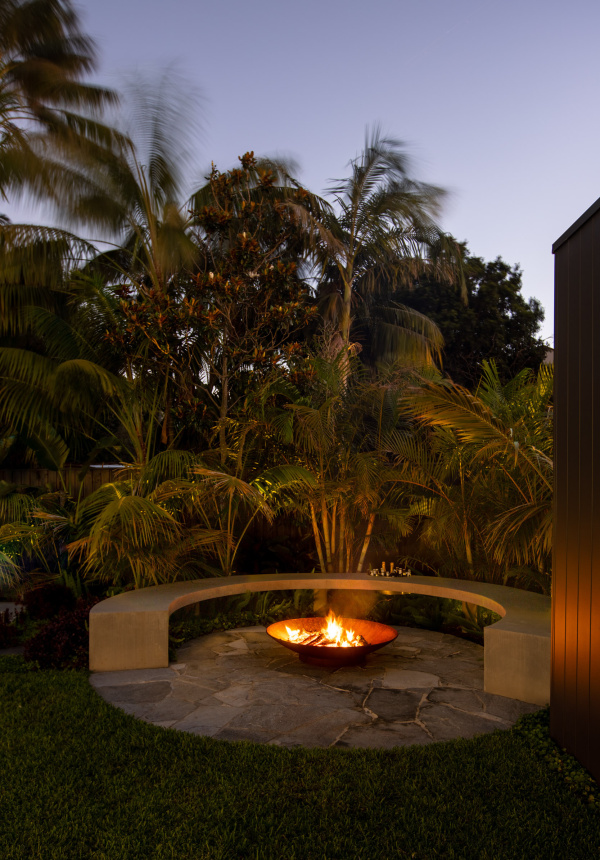 Rolling Stone Landscapes create a circular bench around metal firepit