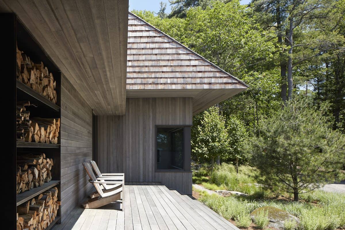 Its exterior, adorned in weathered wood planks and western red cedar shingles, conjures a rustic charm that seamlessly blends with the environment and pre-Cambrian bedrock of northern Ontario.