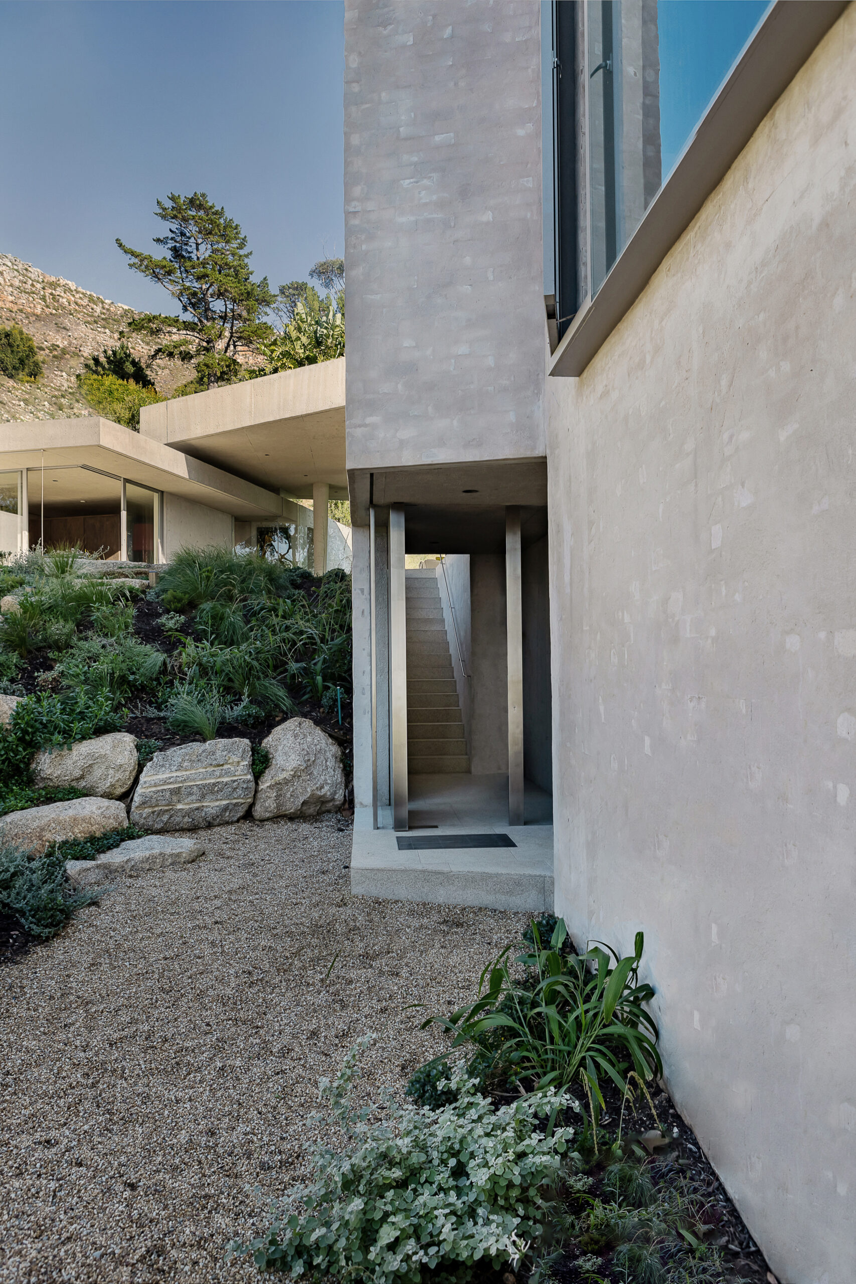 A simple staircase connects the upper level to the lower level informed from the existing terrain, with additional gardens designed by Mary Maurel Gardens.
