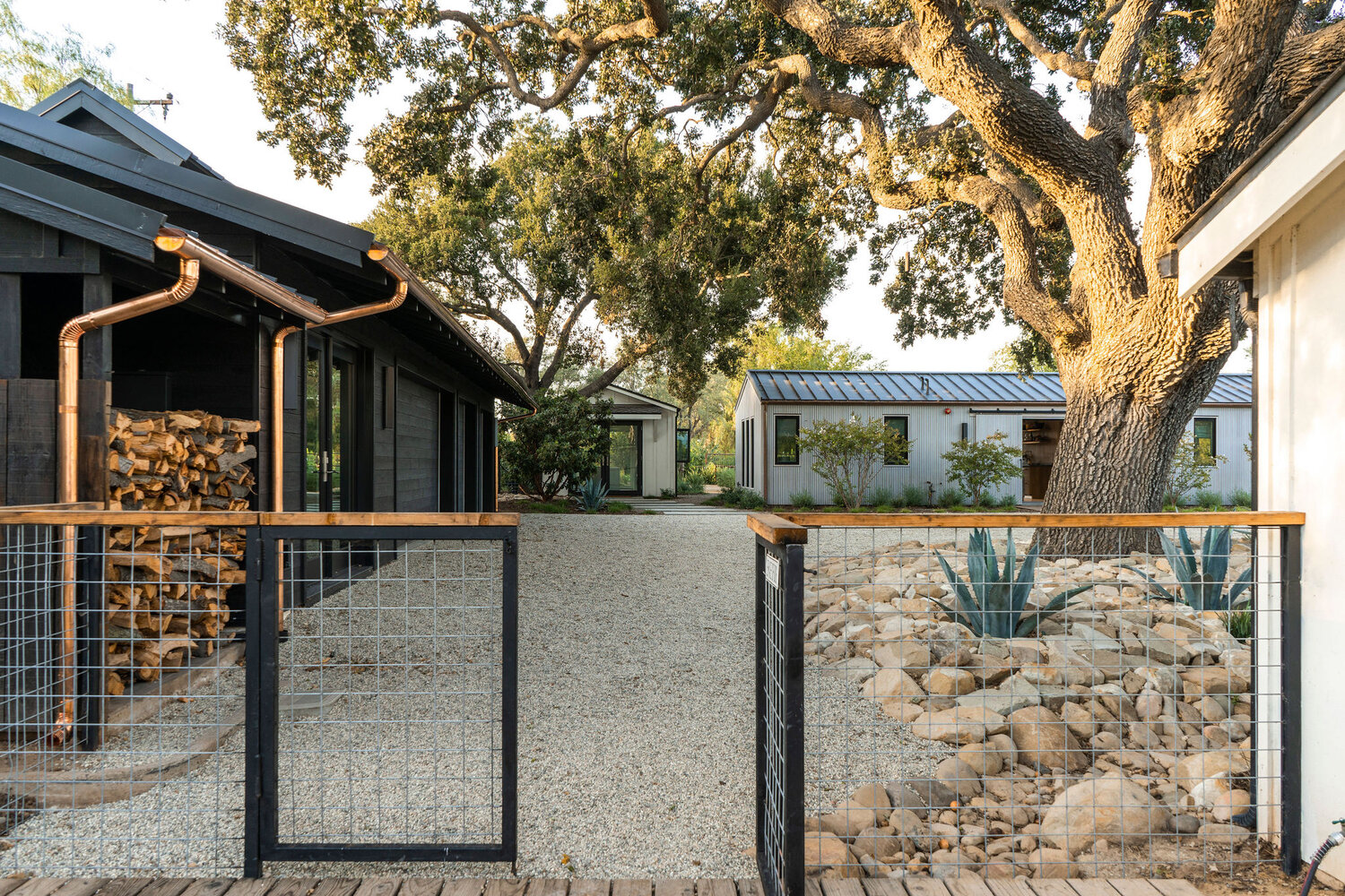 Bosky Landscape Architecture uses wire steel gate to secure gravel drive from backyard