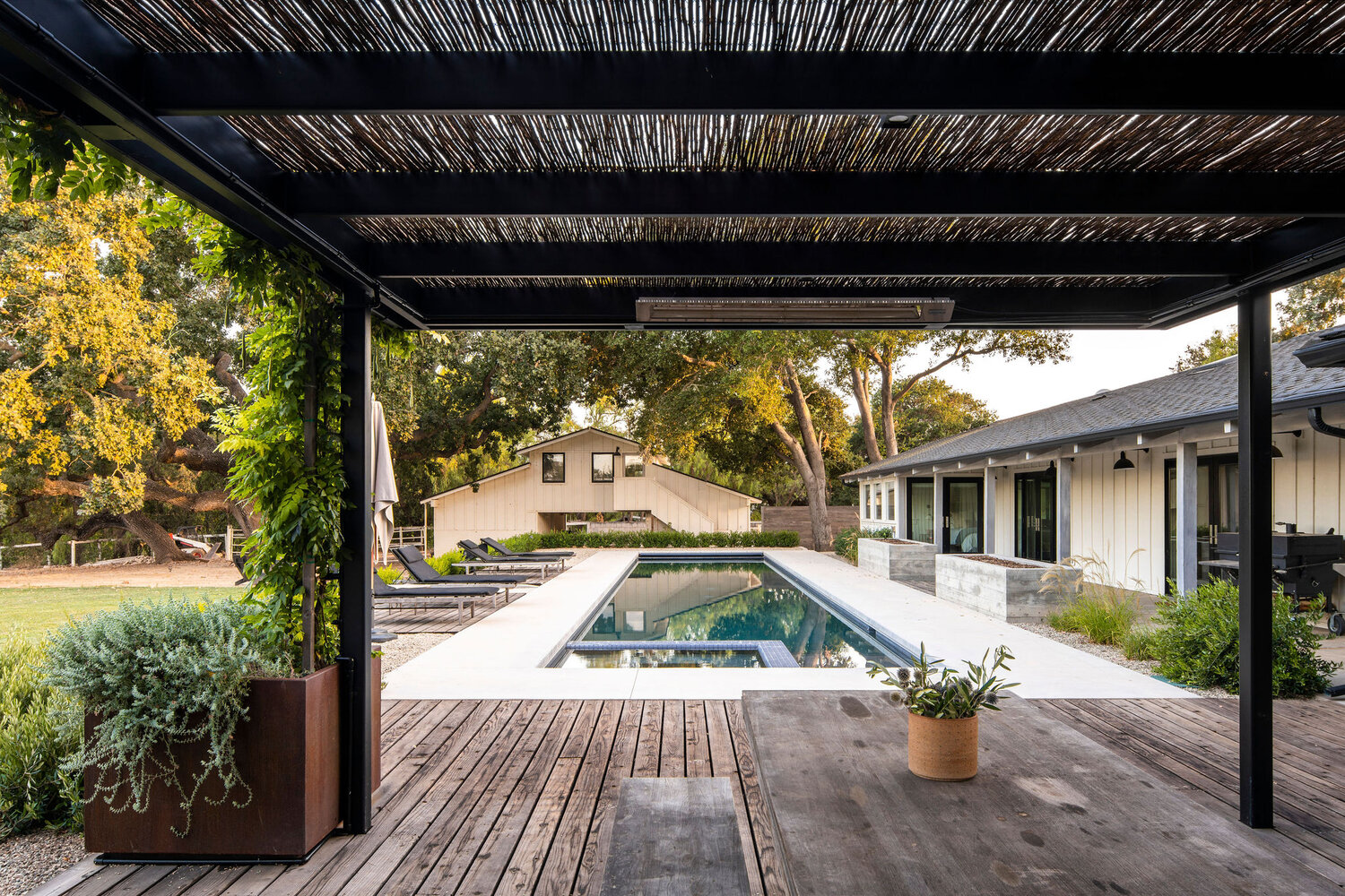 Bosky Landscape architecture centrally locates swimming pool near outdoor covered patios
