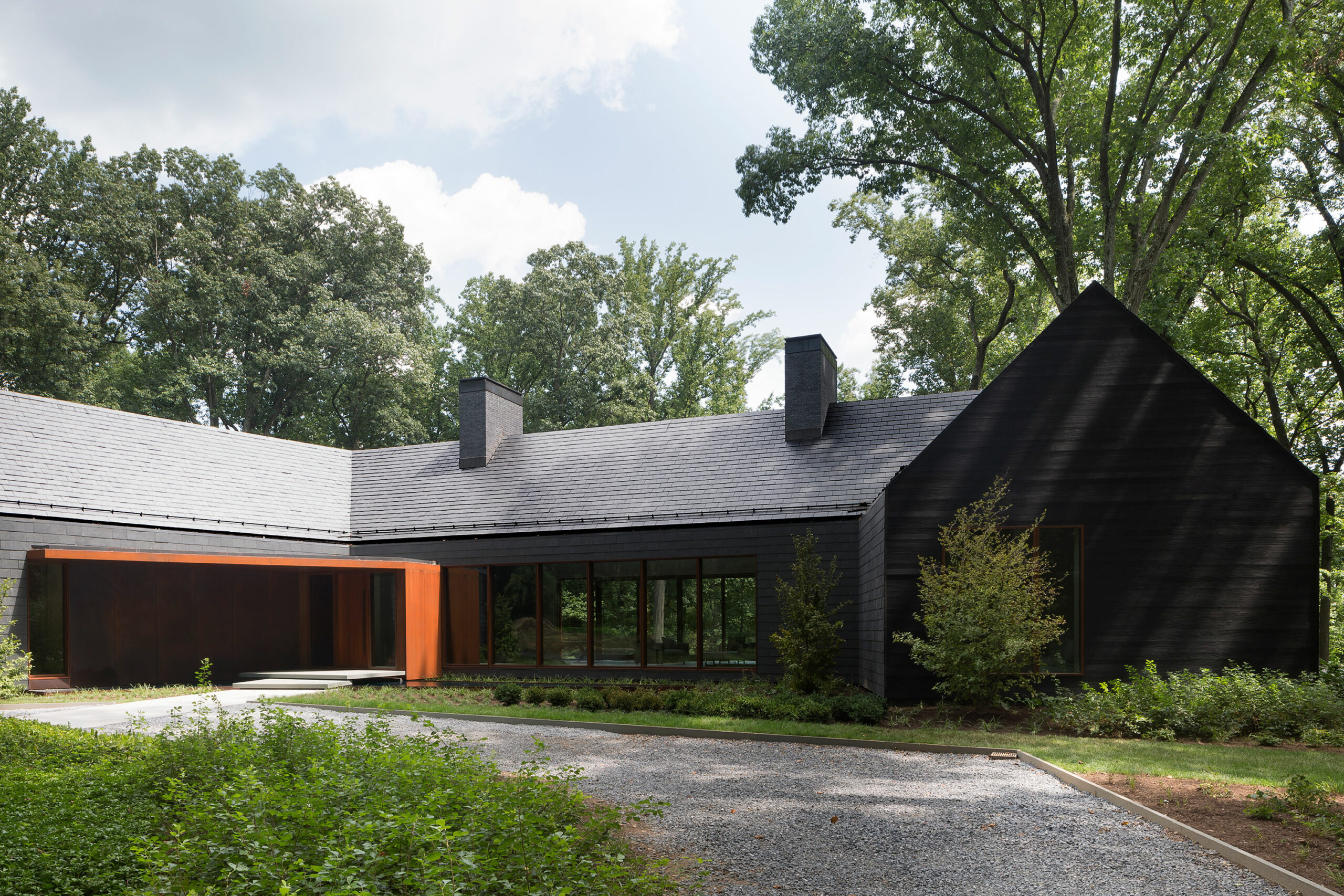 Emerging from the woodlands, this geometrically formed home designed by Ziger Snead Architects, harmoniously integrates with the dense and expansive forest that characterizes its setting.
