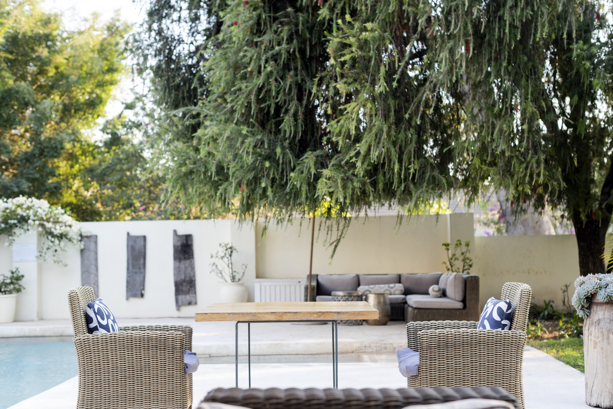 outdoor table and chairs in backyard with a stucco white wall for privacy