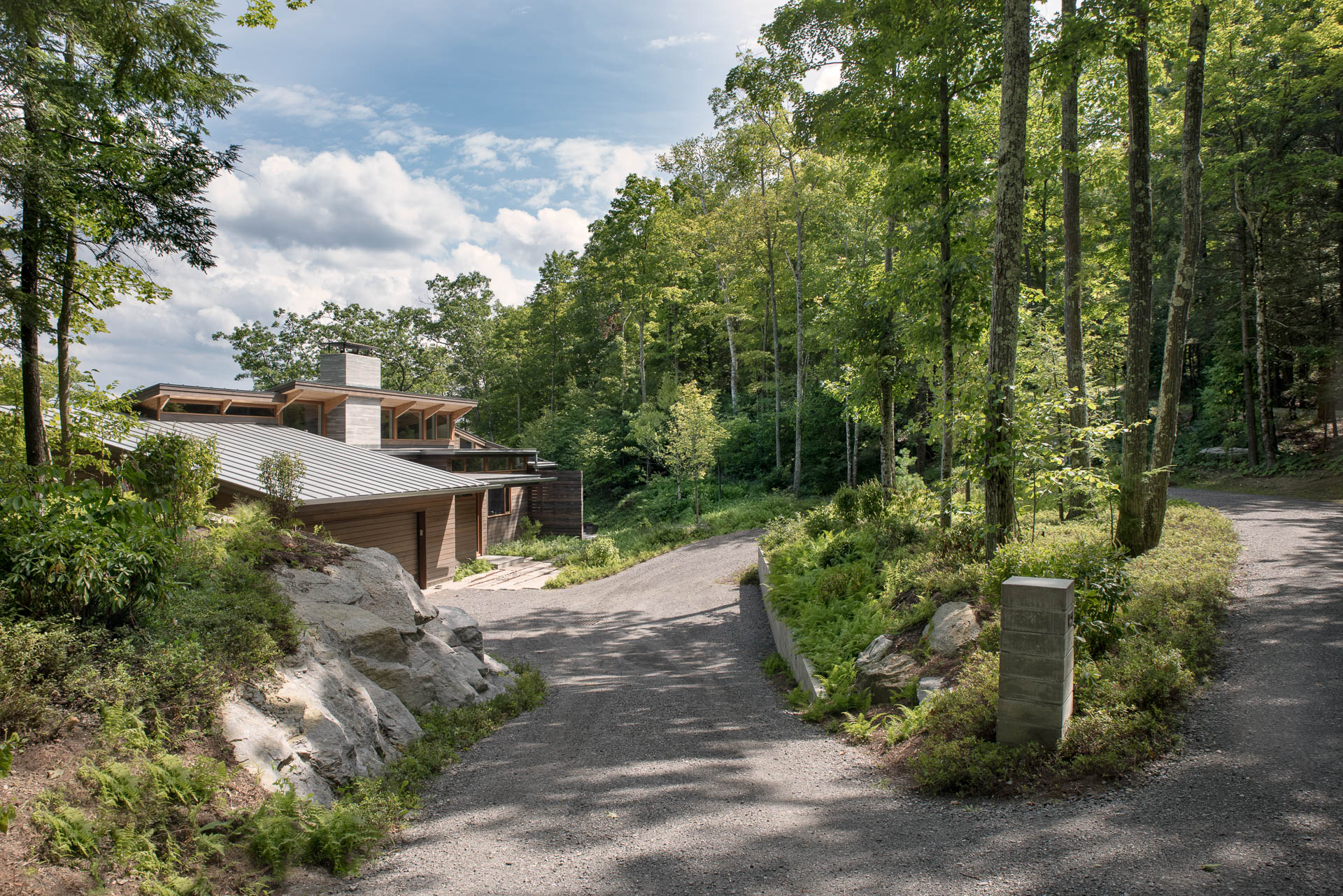 Matthew Cunningham Landscape Design uses crushed stone for driveway near existing granite outcroppings.